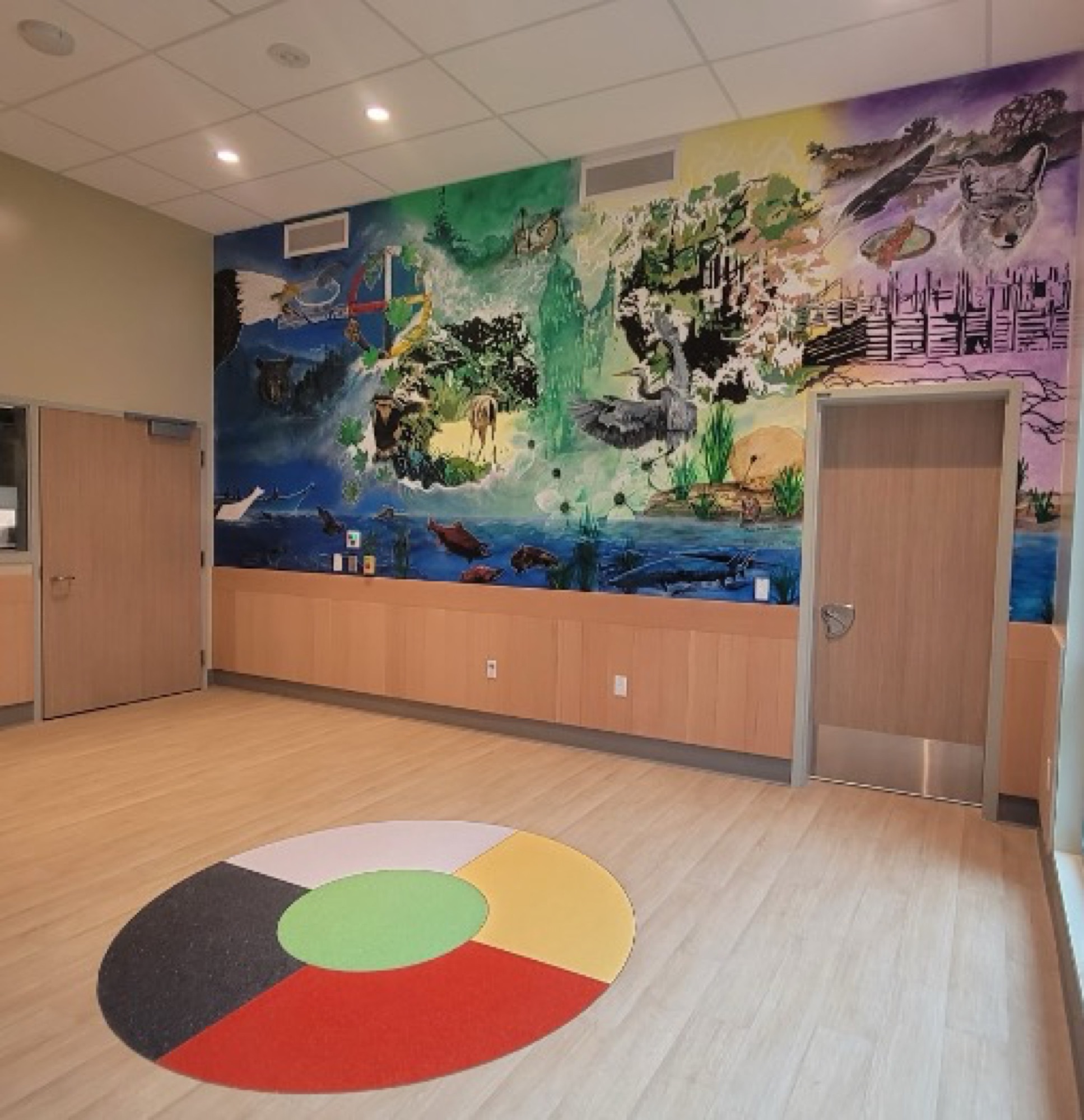 The mural across the healing room, medicine-wheel carpet on the floor