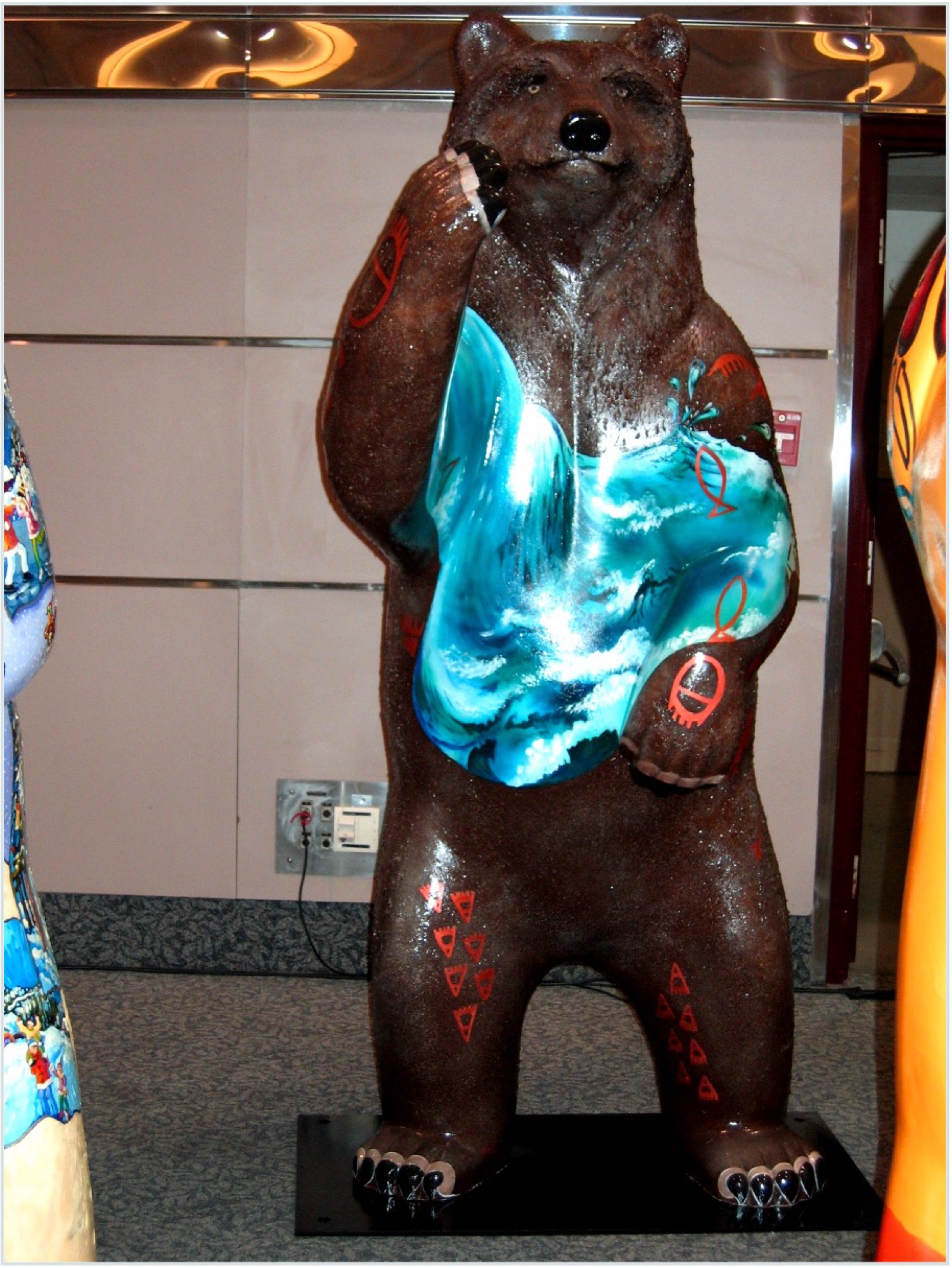 Front of the bear, wave and salmon painted across the chest