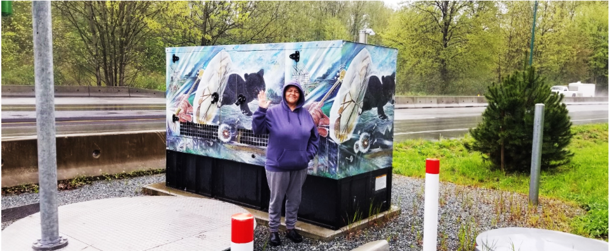 The artist standing in front of the roadside installation
